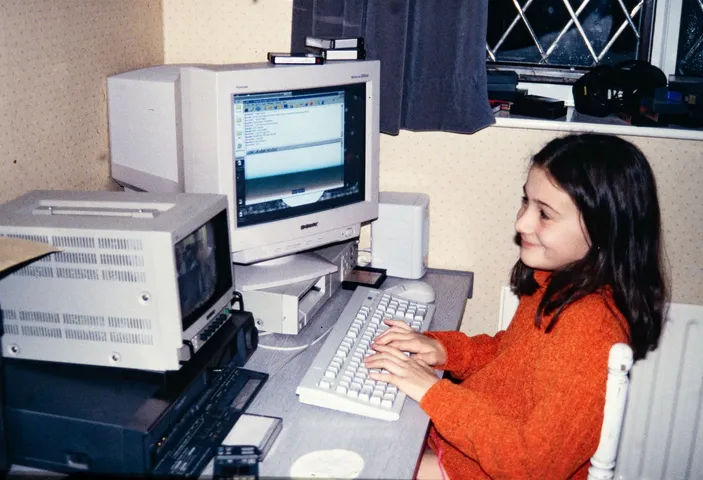 Restored slide of a girl using a computer at a bedroom desk